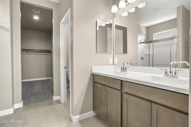 1471 S 239th Dr, Buckeye, AZ 85326 - bathroom with a shower stall, baseboards, double vanity, and a spacious closet