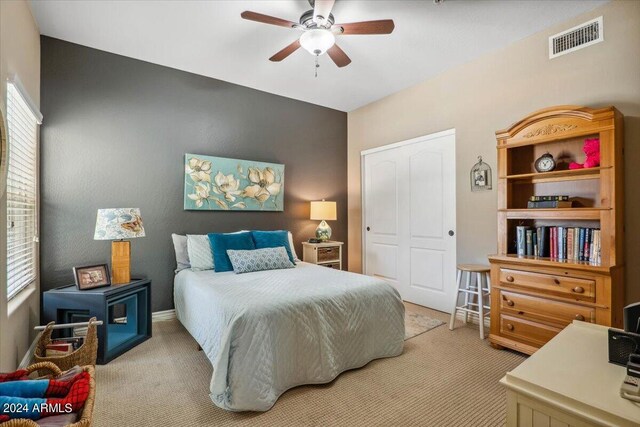 carpeted bedroom featuring a closet and ceiling fan