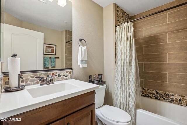 full bathroom featuring shower / tub combo, vanity, toilet, and tasteful backsplash