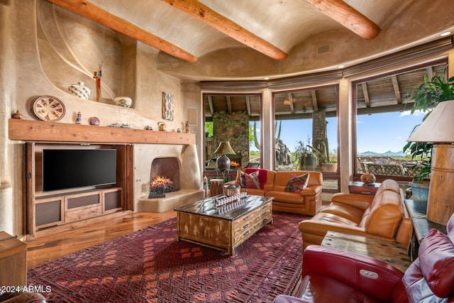 living room featuring beamed ceiling, a premium fireplace, and hardwood / wood-style floors