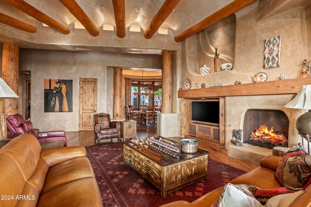 living room featuring hardwood / wood-style flooring, a premium fireplace, and beamed ceiling