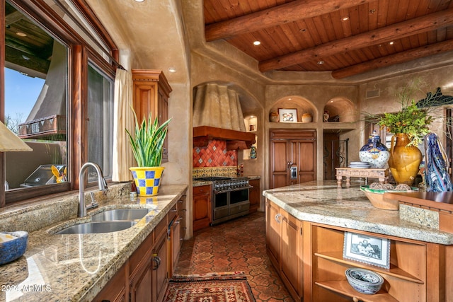 kitchen with high end appliances, light stone countertops, and sink