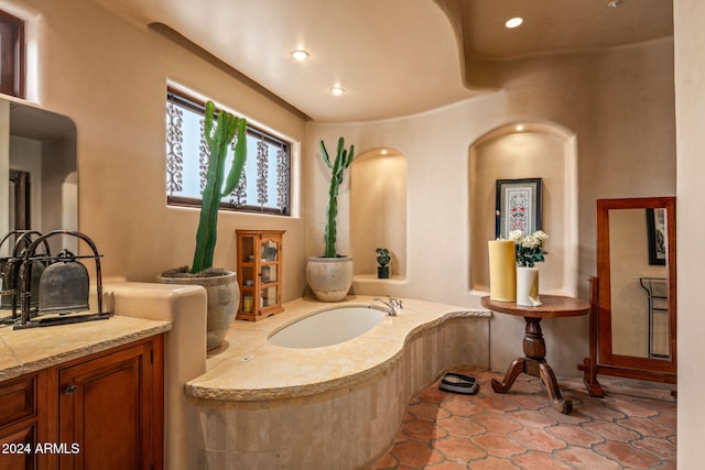 bathroom with vanity and a relaxing tiled tub