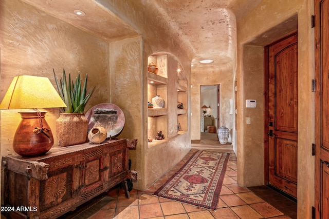 hall featuring light tile patterned floors and built in features