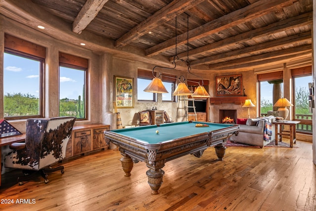 game room with wood ceiling, a high end fireplace, beamed ceiling, and light wood-type flooring