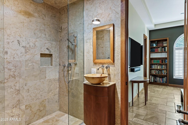 bathroom with a walk in shower, vanity, and stone tile flooring