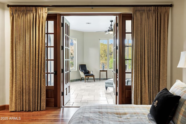 bedroom with french doors, stone tile flooring, and baseboards
