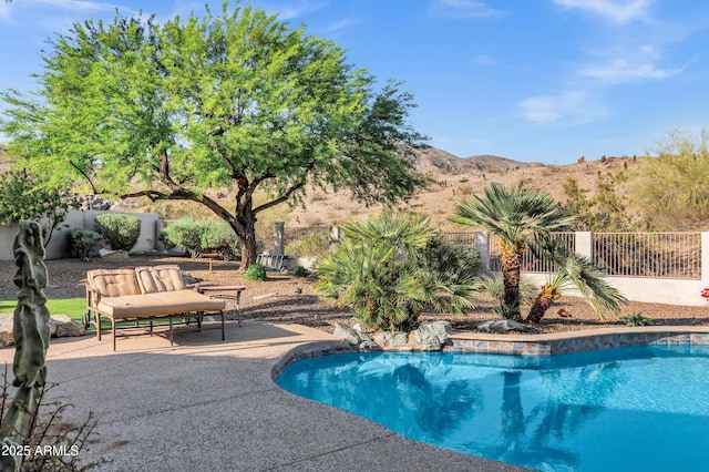 view of swimming pool featuring a mountain view, a fenced backyard, a fenced in pool, and a patio