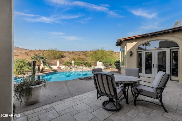 view of patio featuring a fenced in pool, french doors, and outdoor dining space