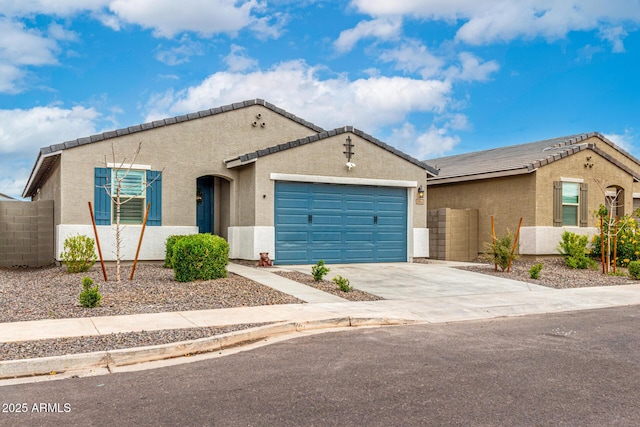 view of front of home featuring stucco siding, a tile roof, fence, concrete driveway, and a garage