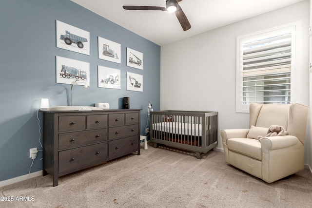 bedroom with light carpet, ceiling fan, baseboards, and a nursery area