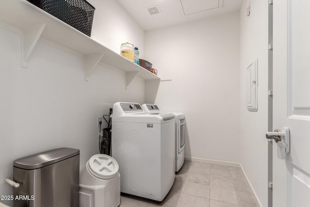 clothes washing area with visible vents, washer and clothes dryer, light tile patterned floors, baseboards, and laundry area