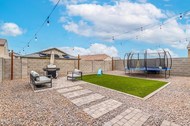 view of yard with a patio, a trampoline, and a fenced backyard