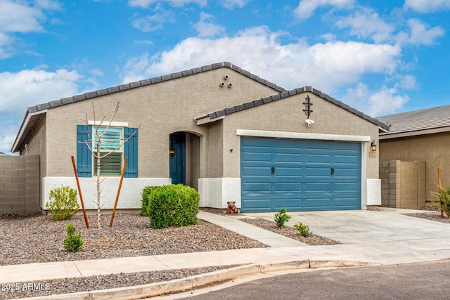 view of front of property with stucco siding, driveway, an attached garage, and fence