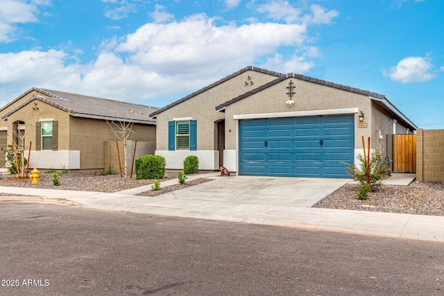 view of front of property featuring stucco siding, a gate, fence, concrete driveway, and an attached garage