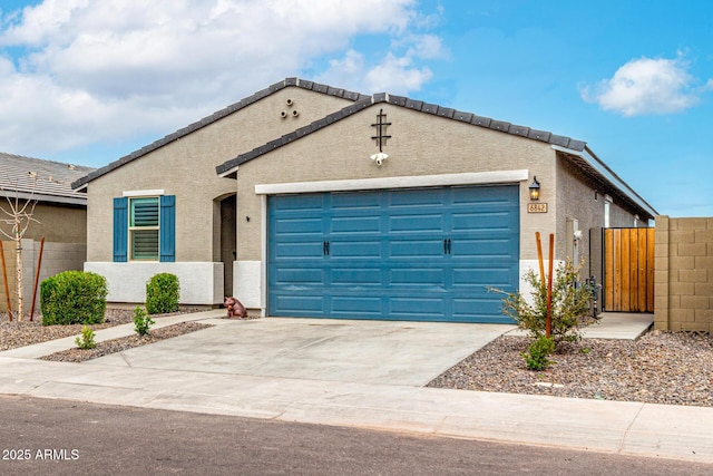 ranch-style home with stucco siding, concrete driveway, an attached garage, and fence