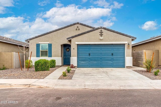 view of front of home featuring stucco siding, a garage, concrete driveway, and fence