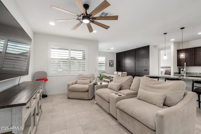 living area with light tile patterned floors, recessed lighting, baseboards, and ceiling fan