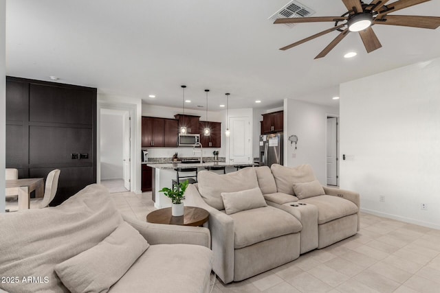 living area featuring visible vents, recessed lighting, a ceiling fan, and baseboards