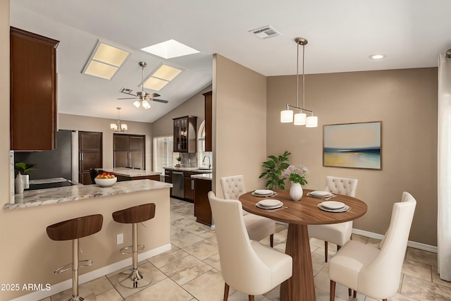 dining space with baseboards, vaulted ceiling with skylight, visible vents, and a ceiling fan