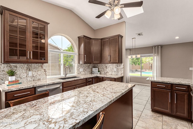 kitchen featuring lofted ceiling, a sink, dark brown cabinets, stainless steel dishwasher, and decorative backsplash