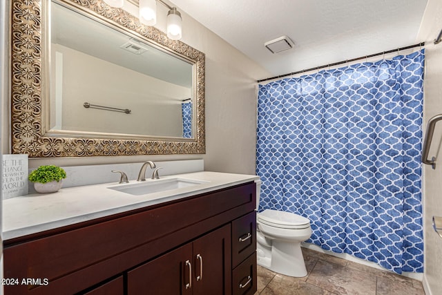 bathroom featuring curtained shower, stone tile flooring, visible vents, toilet, and vanity