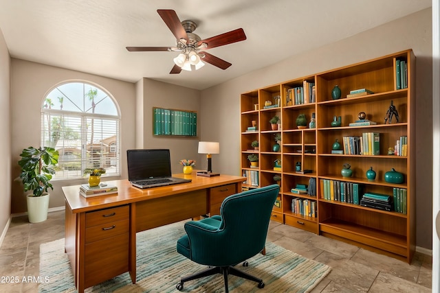 home office with a ceiling fan and baseboards