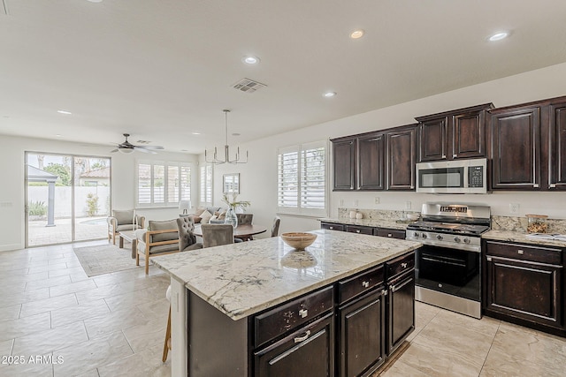 4067 S White Dr, Chandler, AZ 85249 - kitchen featuring stainless steel appliances, light stone counters, ceiling fan, recessed lighting, and a center island