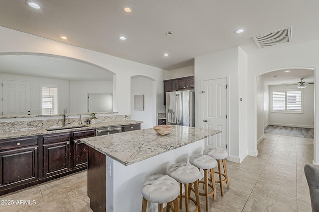 4067 S White Dr, Chandler, AZ 85249 - kitchen with stainless steel appliances, arched walkways, a sink, a kitchen bar, and recessed lighting