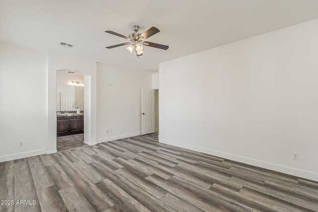 4067 S White Dr, Chandler, AZ 85249 - unfurnished room with ceiling fan, wood finished floors, arched walkways, and baseboards