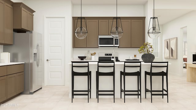 kitchen featuring pendant lighting, a kitchen bar, and appliances with stainless steel finishes