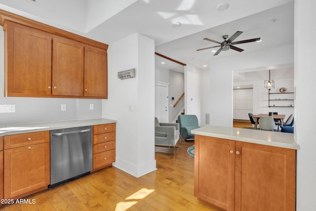 kitchen with brown cabinets, light wood-style floors, light countertops, and dishwasher