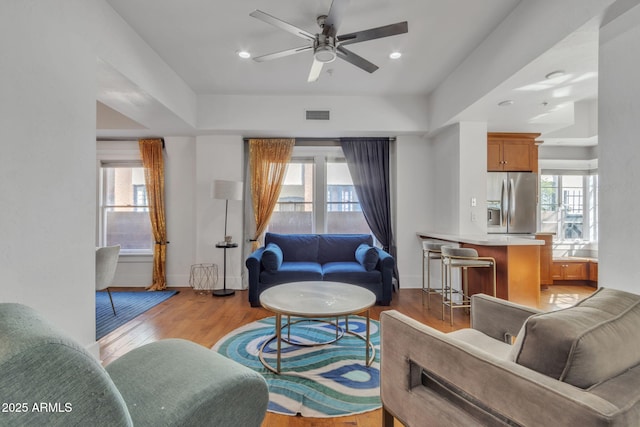 living room featuring light wood-style floors, a healthy amount of sunlight, and visible vents