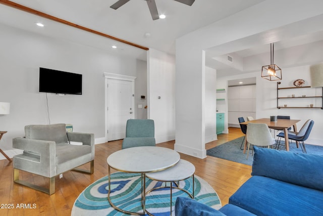 living area with wood-type flooring, baseboards, and recessed lighting