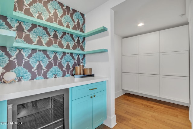 bar featuring beverage cooler, light wood-style flooring, and recessed lighting