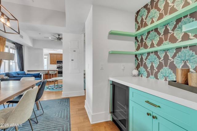 kitchen featuring beverage cooler, stainless steel appliances, light wood-style floors, light countertops, and open shelves