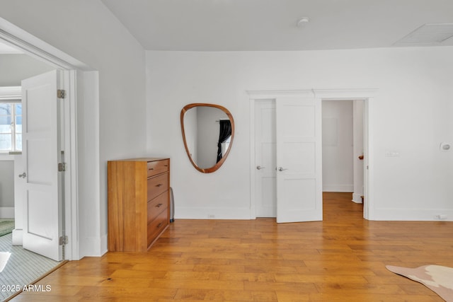 bedroom with light wood-style flooring and baseboards