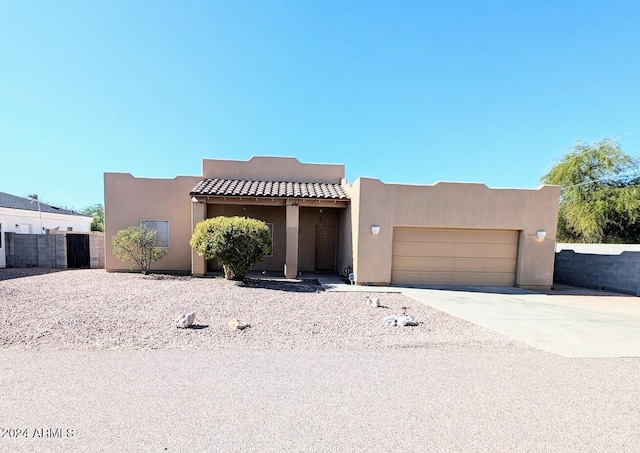 pueblo revival-style home featuring a garage