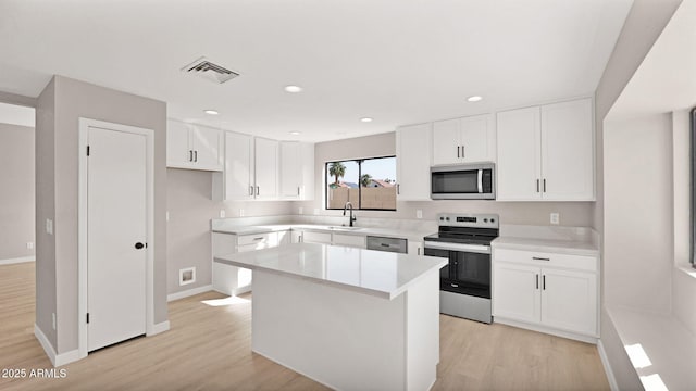 kitchen with light wood-type flooring, visible vents, a kitchen island, and appliances with stainless steel finishes