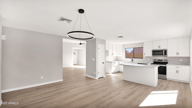 kitchen featuring stainless steel appliances, light countertops, visible vents, white cabinetry, and light wood-type flooring