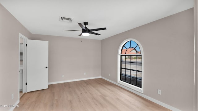 spare room featuring light wood-type flooring, baseboards, visible vents, and a ceiling fan