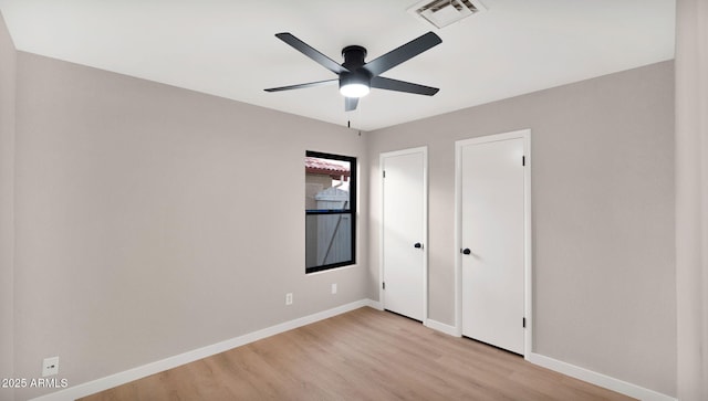 unfurnished bedroom featuring visible vents, ceiling fan, light wood finished floors, and baseboards