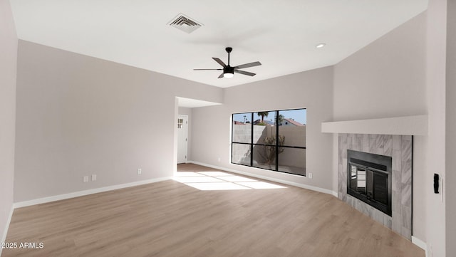 unfurnished living room featuring a fireplace, light wood finished floors, visible vents, ceiling fan, and baseboards