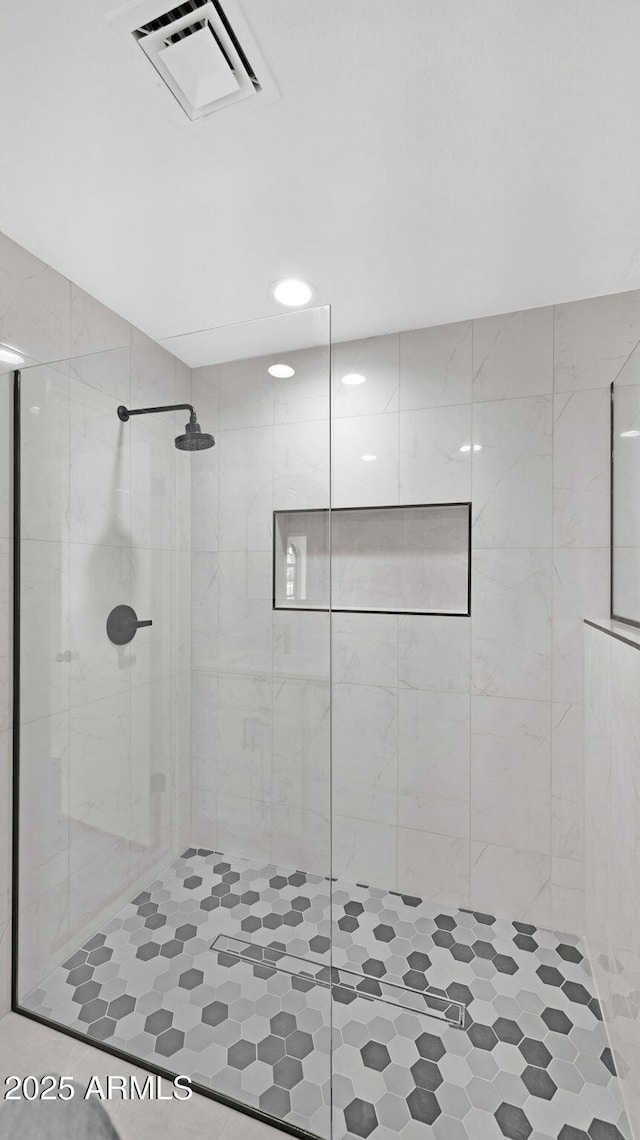 bathroom with a shower stall and visible vents