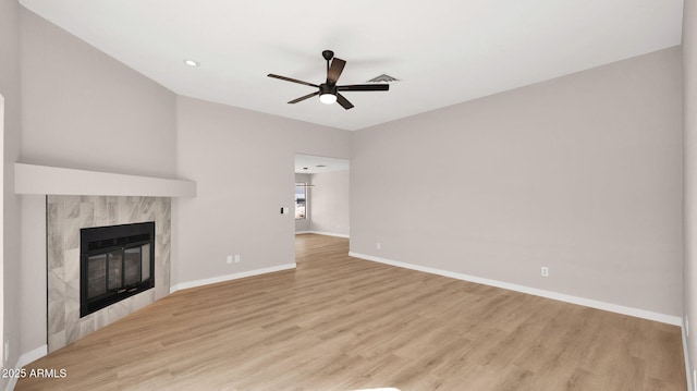 unfurnished living room with ceiling fan, light wood-style flooring, a fireplace, visible vents, and baseboards