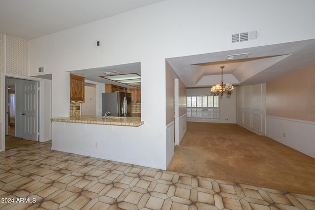 interior space featuring lofted ceiling, a chandelier, sink, and light colored carpet