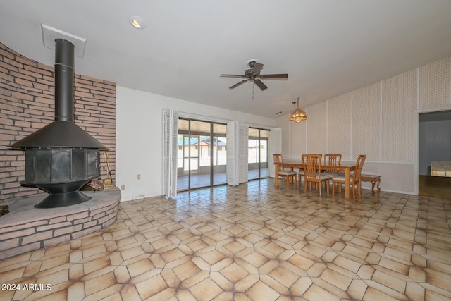 interior space with a wood stove and ceiling fan