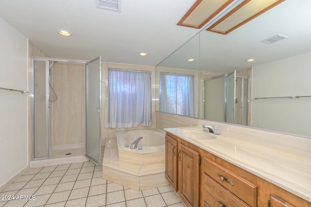 bathroom with tile patterned flooring, shower with separate bathtub, and vanity