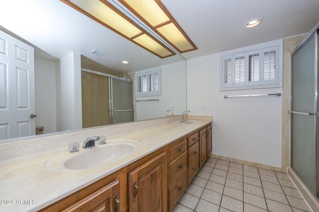 bathroom with tile patterned flooring, a shower with door, and vanity