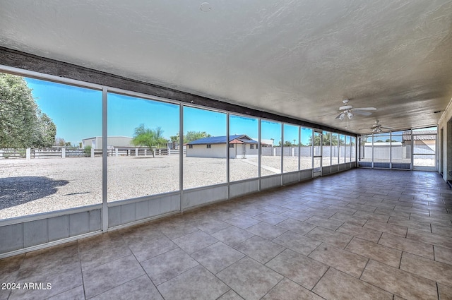 unfurnished sunroom with ceiling fan